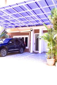 a black car parked in front of a house at Coast to Coast Homes in Gwarinpa