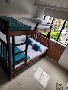 two bunk beds in a room with a window at Habitación Coliving Marce Ibagué in Ibagué