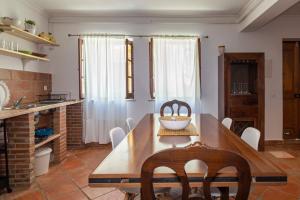a kitchen with a wooden table and chairs at Casa David Duplex in Olhão