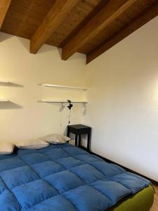 a bedroom with a blue bed and a table at Inserrata Abetone in Tuscany in Abetone