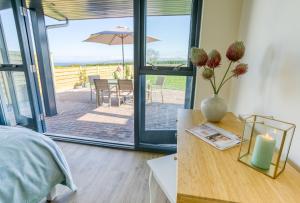 a bedroom with a bed and a table with a candle at 2 Trem Y Mor in Moelfre