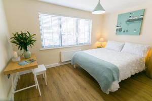 a bedroom with a bed and a table and a window at 2 Trem Y Mor in Moelfre