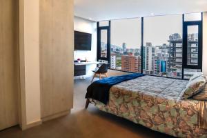 キトにあるHarmony Staysのベッドと大きな窓のある寝室 +126枚の写真