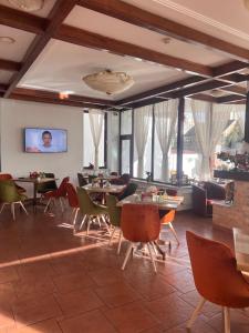 a living room with tables and chairs and windows at Casa Jasmine in Braşov