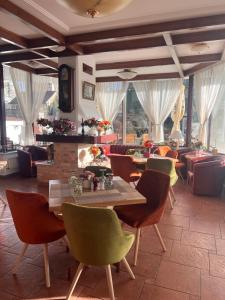 a dining room with tables and chairs and windows at Casa Jasmine in Braşov