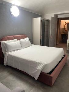 a bedroom with a large bed with white sheets and pillows at airport apartments camera orchidea in San Maurizio Canavese +16 photos
