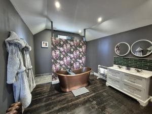 a bathroom with a tub and a sink at Squirrel Cottage in Ballymena +26 photos