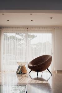 a chair and a table in a room with a large window at L'eros Hotel in Ayia Napa