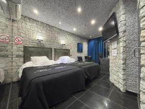 a bedroom with a large bed in a brick wall at Hotel Plata in Ibi