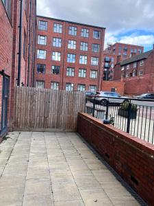 a wooden fence in front of a building with buildings at DELEHoUSE in Birmingham