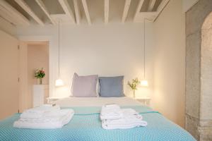 a bedroom with a bed with towels on it at Antiga Casa Pessoa in Lisbon +151 photos