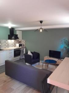 a living room with a couch and a kitchen at Le coucou, studio tout équipé proche gare in Saint-Brieuc