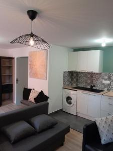 a living room with a couch and a kitchen at Le coucou, studio tout équipé proche gare in Saint-Brieuc