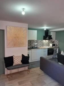 a living room with a couch and a kitchen at Le coucou, studio tout équipé proche gare in Saint-Brieuc +3 photos