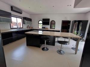 a kitchen with a table and two bar stools at Villa Michel Lucas in Marrakesh
