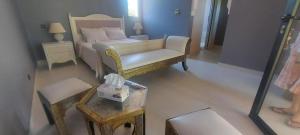 a bedroom with a bed and a chair and a table at Villa Michel Lucas in Marrakesh