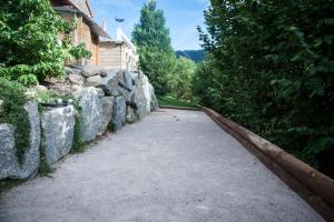 a driveway with a stone wall next to a house at Chalet LES BICHES LUCY in Gérardmer