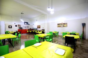 una sala da pranzo con tavoli gialli e sedie verdi di Hotel da Ettore - Salento Selection a Porto Cesareo Altre 23 foto