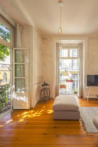 a living room with a bed and a sliding glass door at Antiga Casa Pessoa in Lisbon