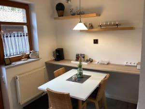 eine Küche mit einem weißen Tisch und Stühlen in der Unterkunft Landhaus Saterland Ferienwohnung in Sedelsberg