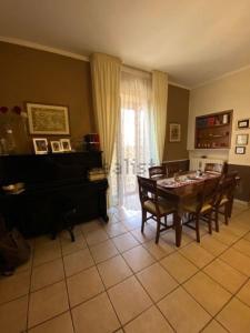 Una sala de estar con una mesa y un piano. en Home Igino&Rose, en San Pietro in Guarano
