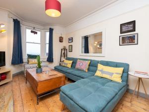 a living room with a blue couch and a table at Spacious one bed house with parking - Pass the Keys in Bath