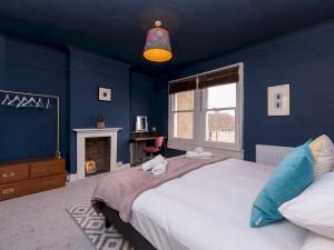 a blue bedroom with a bed and a fireplace at Spacious one bed house with parking - Pass the Keys in Bath