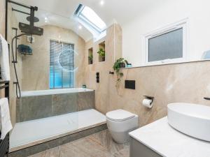 a bathroom with a tub and a toilet and a sink at Spacious one bed house with parking - Pass the Keys in Bath +16 photos