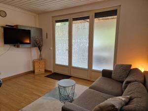 a living room with a couch and a tv at Le Devant de la Chaux in Pontaix