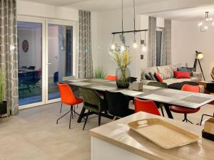 a dining room and living room with a table and chairs at Neues Ferienhaus für Familien mit Garten und Sauna in Butjadingen +12 photos