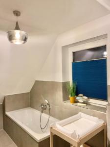 a bathroom with a bath tub and a window at Neues Ferienhaus für Familien mit Garten und Sauna in Butjadingen