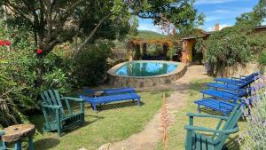 a group of blue chairs next to a swimming pool at Landhaus Samaipata in Samaipata