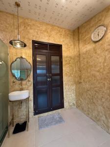 ein Badezimmer mit einem Waschbecken und einer Uhr an der Wand in der Unterkunft Luan Heritage Surawong in Bangkok + 39 Fotos