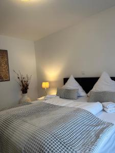 een slaapkamer met 2 bedden met witte lakens en een lamp bij Premium Apartment 2 Cathedral in Keulen