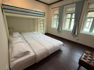 ein Schlafzimmer mit einem Bett und einem Etagenbett in der Unterkunft Luan Heritage Surawong in Bangkok