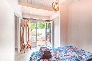 ein Schlafzimmer mit einem Bett, einem Spiegel und einem Fenster in der Unterkunft maison 50 m de la plage in La Guérinière
