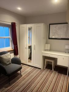 - un salon avec une chaise et un bureau dans l'établissement River Cottage Hot tub spa, à Drumnadrochit