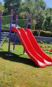 a red slide on a playground in a park at Ira Homestay By StayApart in Attigundi