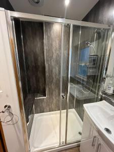 une douche avec une porte vitrée dans une salle de bain dans l'établissement River Cottage Hot tub spa, à Drumnadrochit 25 autres photos