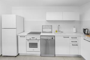 a kitchen with white appliances and white cabinets at Luxury Penthouse With Sea View #65 By Hashdera Eilat in Eilat