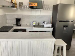 a small kitchen with a sink and a refrigerator at Casa GALLARDO in Manzanillo