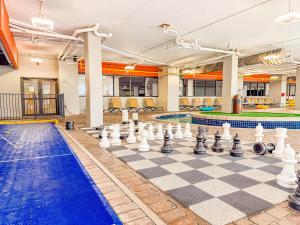 マートルビーチにあるTropical Suite at Oceanfront Resort w Lazy Riverのチェス盤とプール付きの客室