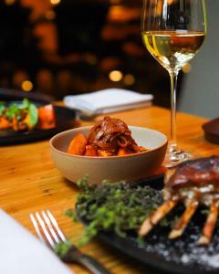 a table with a bowl of food and a glass of wine at east Hotel Hamburg in Hamburg