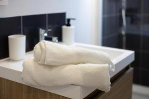 un asciugamano bianco appoggiato su un lavandino in un bagno di La Cachette Centre-Ville a Saint-Étienne
