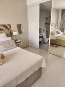 a bedroom with two beds and a mirror at Boa Mindelo Beach in Mindelo