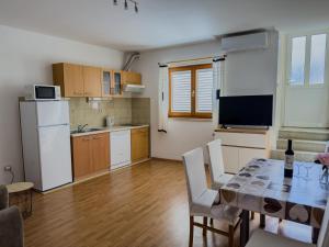 een keuken en eetkamer met een tafel en stoelen bij Apartments Marin Tomas in Dubrovnik +22 foto's