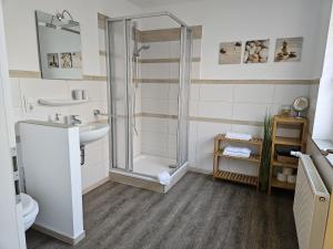 ein Badezimmer mit Dusche, Waschbecken und Toilette in der Unterkunft N Hotel in Nottuln