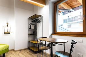 a table and chairs in a room with a window at Le Coin Du Bois Chambre d'Hotes in Nus