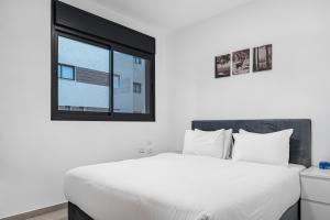 una camera da letto con un letto bianco e una finestra di Luxury Suite Apartment #68 By Hashdera Eilat a Eilat Altre 10 foto