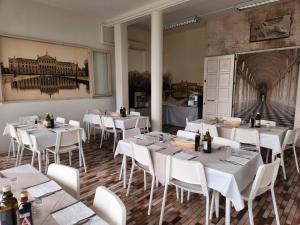 a dining room with white tables and white chairs at Hotel The Click - Art & Colors in Cazzago di Pianiga
